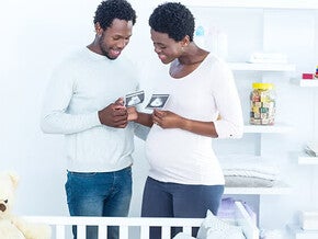 Pregnant couple looking at ultrasounds of their baby.