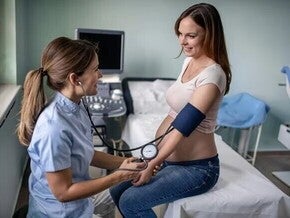 Pregnant woman at a medical appointment taking her blood pressure