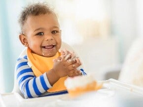 A baby eating solid food by himself, the baby-led weaning method. 