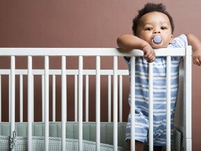 It's important to do some baby proofing strategies in your home. A Baby boy standing in cot