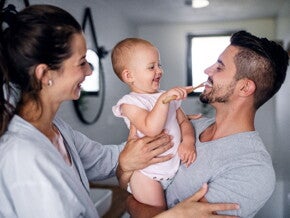 Learn some tips to apply during baby teething A child learning how to brush her teeth with her parents while she’s teething