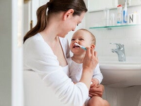 Children’s dental care is important for e healthy development. A mother taking care of her children’s dental care