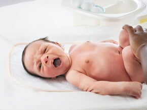 A parent changing the diaper of his newborn to avoid Diaper Rash