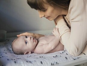 Mother looking at his baby while lying in bed