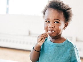 A baby being fed food from a baby meal planner.
