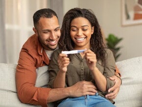 A couple watching a pregnancy test after an ovulation test.