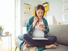 A woman indulging her pregnancy cravings in her home.
