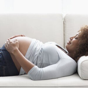 A pregnant woman relaxing on a sofa after some Braxton Hicks contractions.