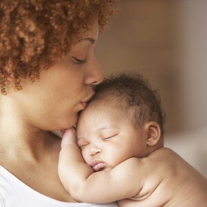 A mother kissing her baby without cradle cap