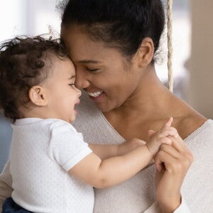 A mother holding her baby filled with new mom emotions.