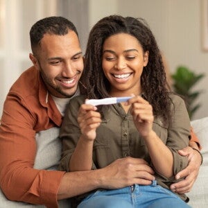 A couple watching a pregnancy test after an ovulation test.