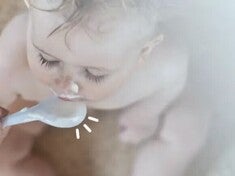 Toddler eating puree from a plastic spoon