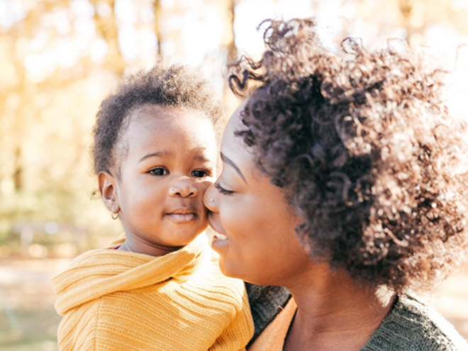 A mother holding her baby to manage newborn hiccups