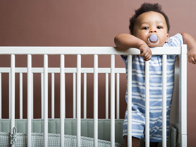 It's important to do some baby proofing strategies in your home. A Baby boy standing in cot