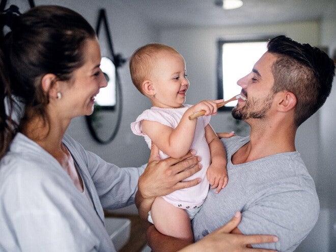 Learn some tips to apply during baby teething A child learning how to brush her teeth with her parents while she’s teething