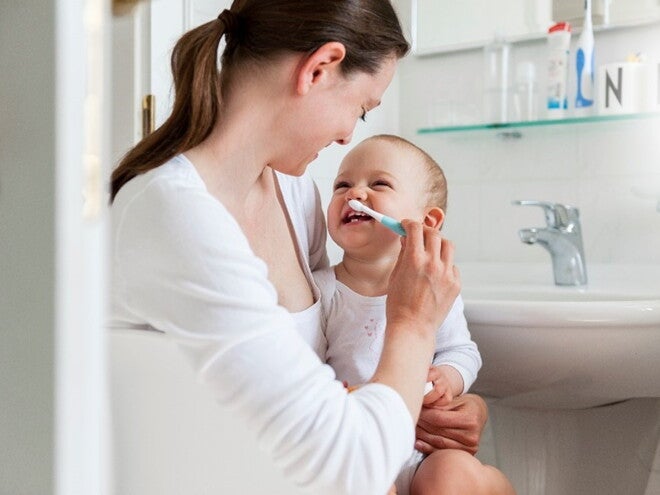 Children’s dental care is important for e healthy development. A mother taking care of her children’s dental care