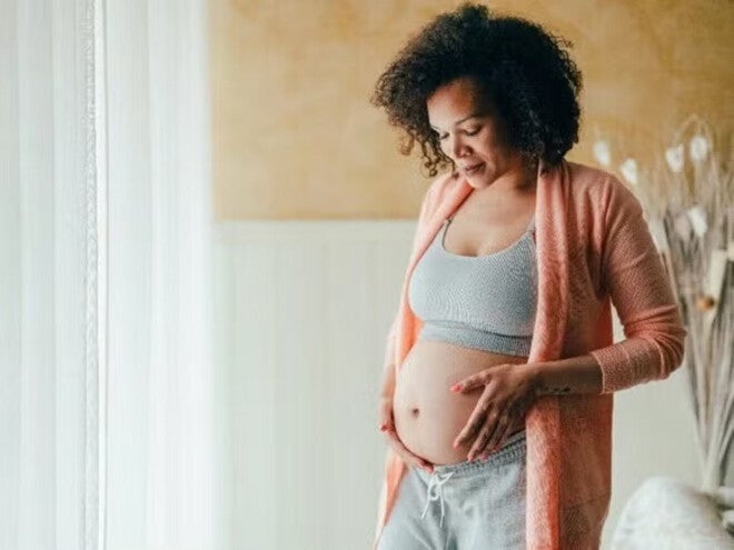 Pregnant women touching her belly with love