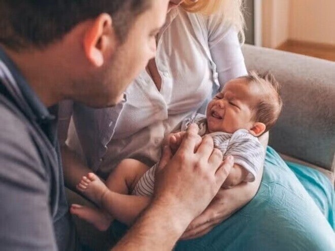 Couple holding and admiring their baby while he cries