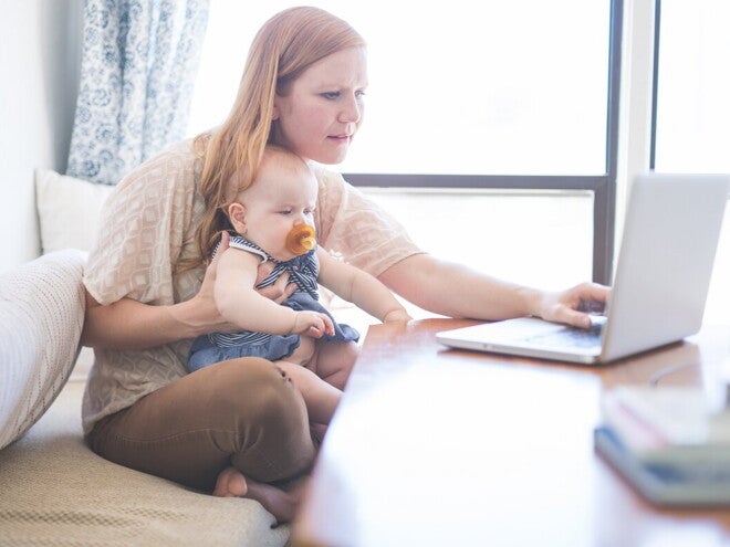 Breast pumps are very useful for modern mothers and their babies. A woman with his son researching breast pumps on her computer.