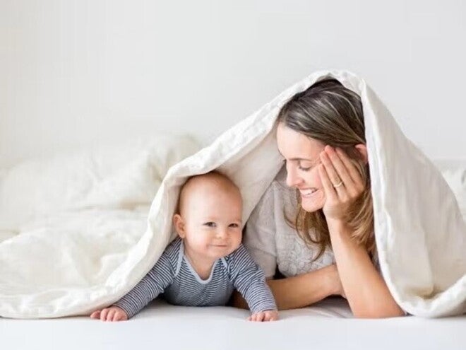 Mom and baby under a cover playing and having fun