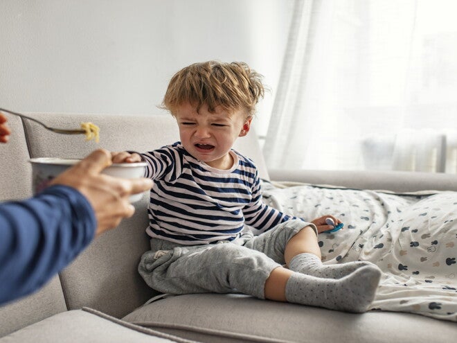 While your child is growing, he can become a picky eater A toddler being a picky eater and rejecting food from his parent.