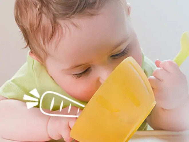 Baby eating his first solids meal from a yellow deep bowl