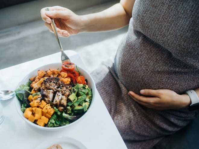 A pregnant woman eating and getting vitamin a in prenatal care
