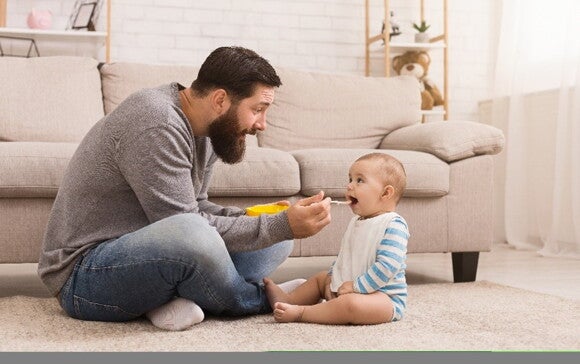 It’s important to celebrate your baby’s first words a father encouraging his baby's first words through communication during meals