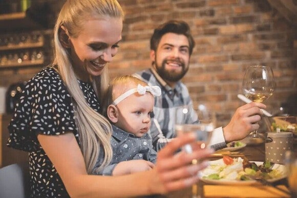 Parents eating salad with their baby girl at a restaurant