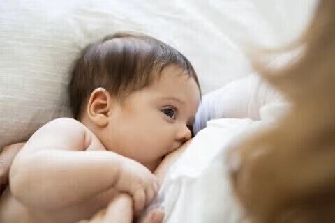 Baby being feed breast milk while looking at mommy’s face