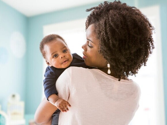 A mother carrying her baby after breastfeeding