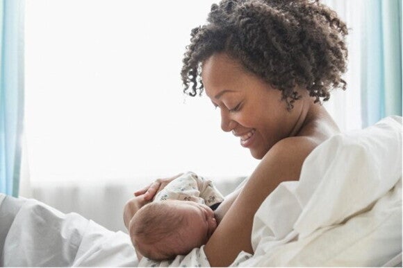 A woman breastfeeding her child in bed