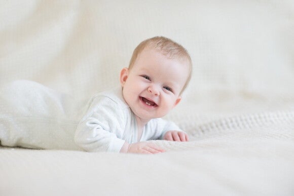 This children’s health care checklist can help your kid to improve his health A baby smiling and showing his dental care.