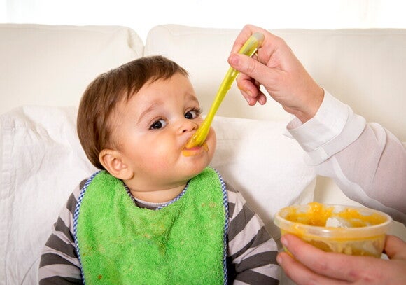 It is vital to establish good habits during mealtime to avoid a fussy toddler. A toddler being feed by one of his parents.