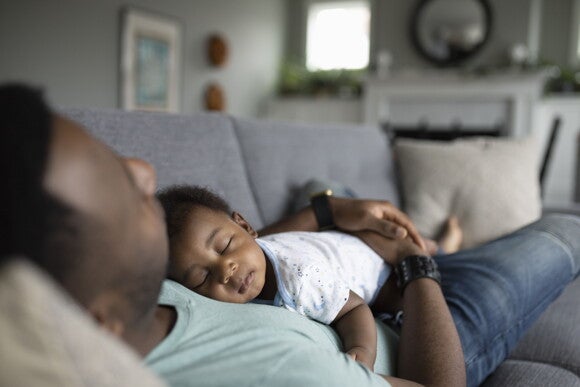 A father holding his baby while it sleeps