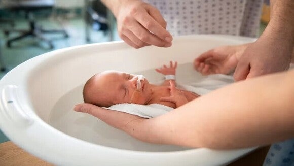 Newborn taking his first bath
