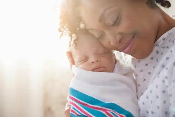 Mom holding and hugging Newborn with hiccups
