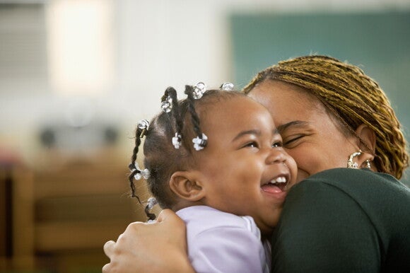 It is important to maintain oral hygiene during teething symptoms. A mother hugging her toddler after teething.